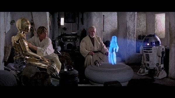 Obi-Wan, Luke and C3-PO watch as R2-D2 plays back a holigraphic recording of Princess Leia.